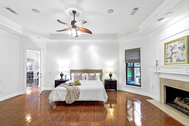 bedroom featuring dark tile patterned floors, visible vents, a tray ceiling, and ornamental molding