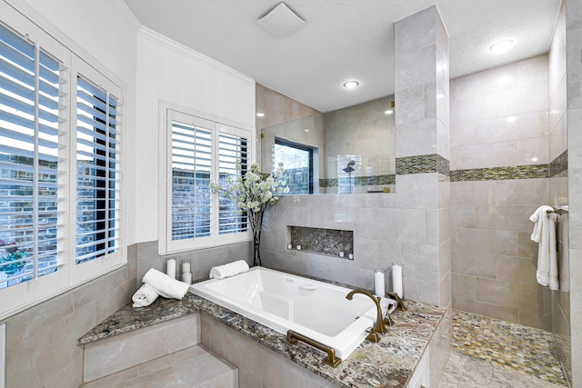 bathroom with tile walls, a garden tub, walk in shower, and crown molding