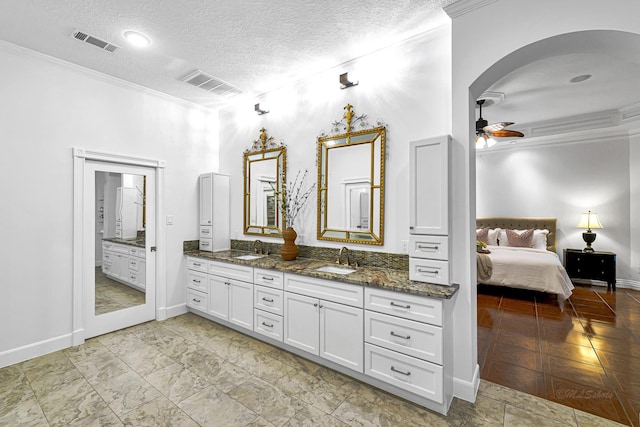 bathroom featuring a sink, visible vents, and crown molding