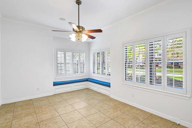 spare room featuring light tile patterned flooring, a ceiling fan, and baseboards