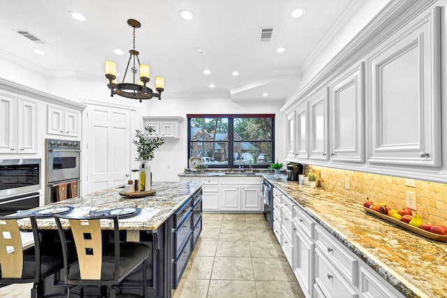 kitchen with visible vents, appliances with stainless steel finishes, crown molding, and white cabinetry