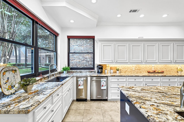 kitchen with a healthy amount of sunlight, visible vents, backsplash, and a sink