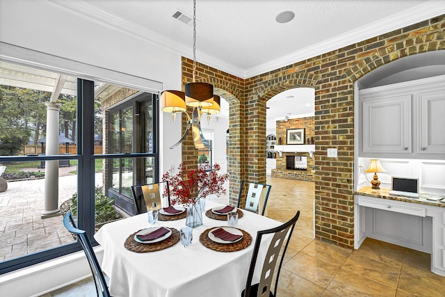 dining space featuring visible vents, a textured ceiling, brick wall, and crown molding