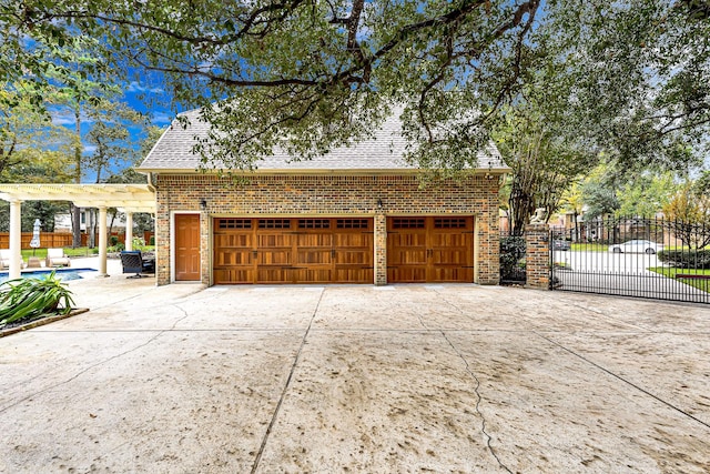 garage featuring driveway and fence