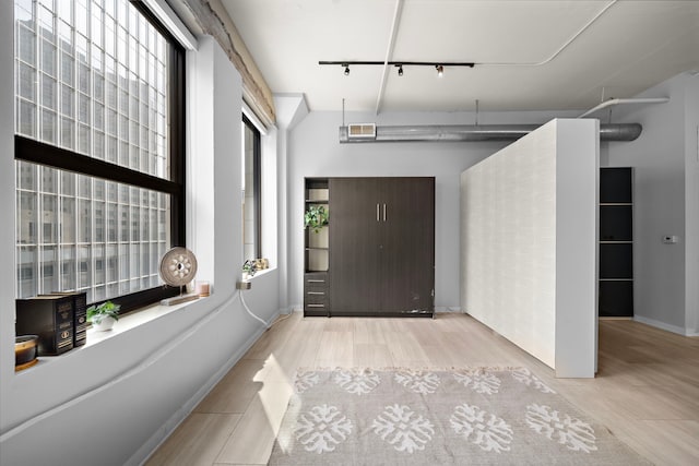 foyer entrance with a healthy amount of sunlight, wood finished floors, and track lighting