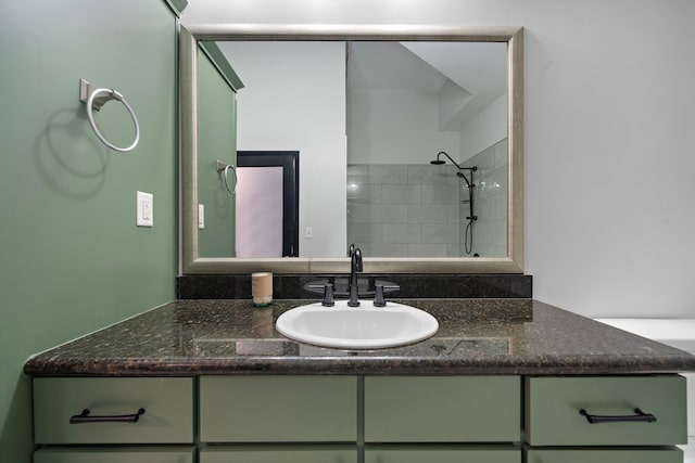 full bathroom with tiled shower and vanity