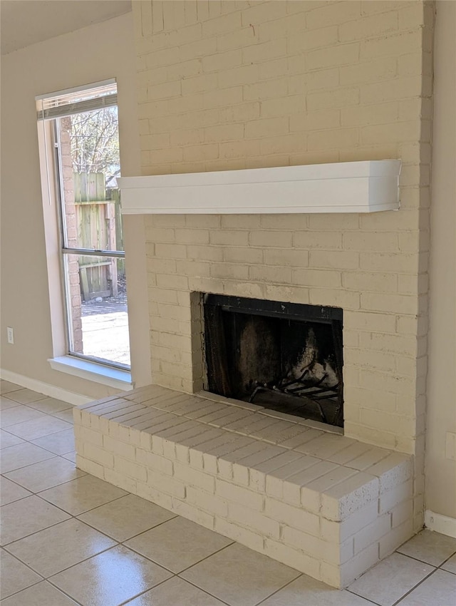 room details featuring baseboards and a brick fireplace