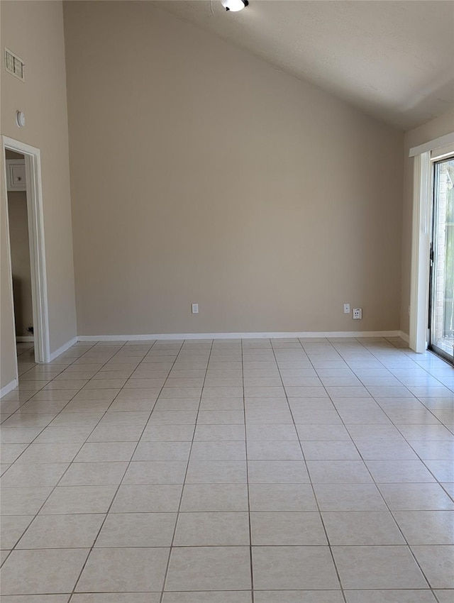 spare room featuring light tile patterned flooring, visible vents, high vaulted ceiling, and baseboards