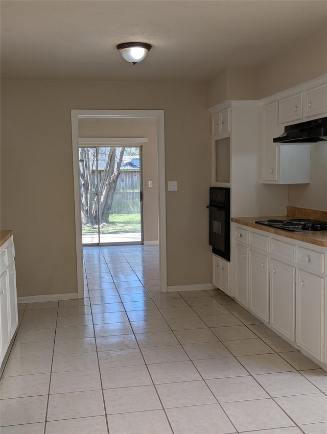 kitchen featuring black appliances, white cabinets, light tile patterned floors, and under cabinet range hood