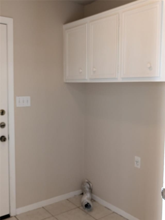 laundry room featuring light tile patterned floors and baseboards