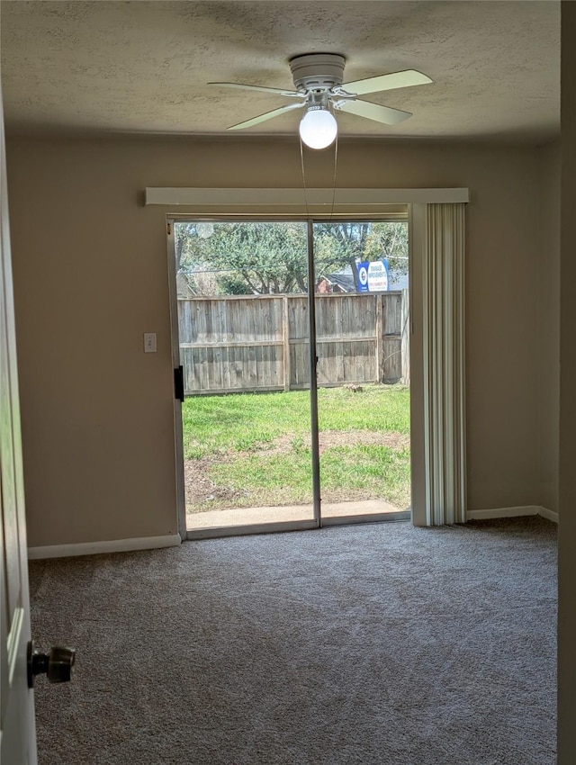 carpeted empty room featuring ceiling fan, baseboards, and a textured ceiling