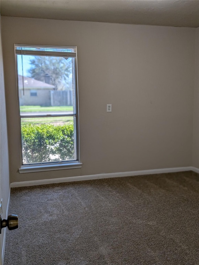 carpeted spare room with baseboards