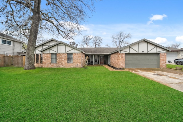 english style home featuring brick siding, fence, a front yard, a garage, and driveway