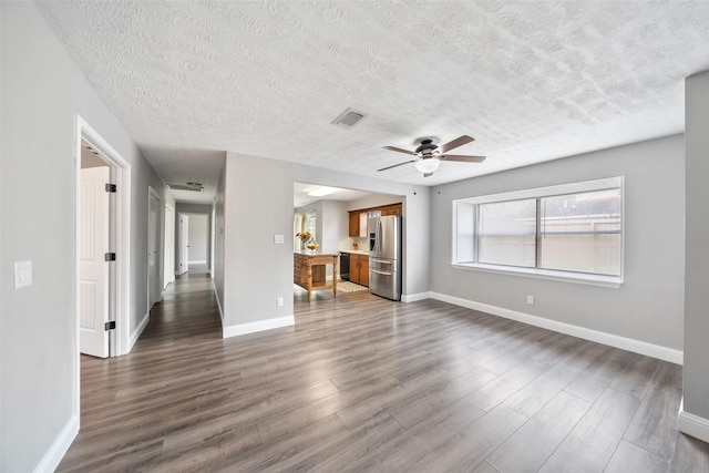 unfurnished living room featuring dark wood-style floors, visible vents, and baseboards