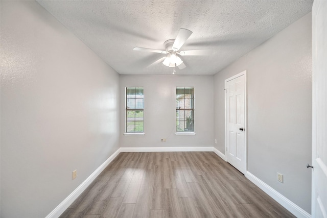 spare room featuring ceiling fan, baseboards, a textured ceiling, and wood finished floors