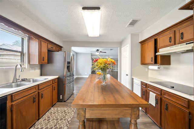 kitchen featuring wood finished floors, wooden counters, black appliances, and a sink