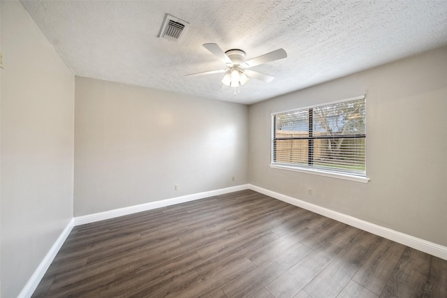 empty room with visible vents, ceiling fan, baseboards, a textured ceiling, and dark wood-style flooring