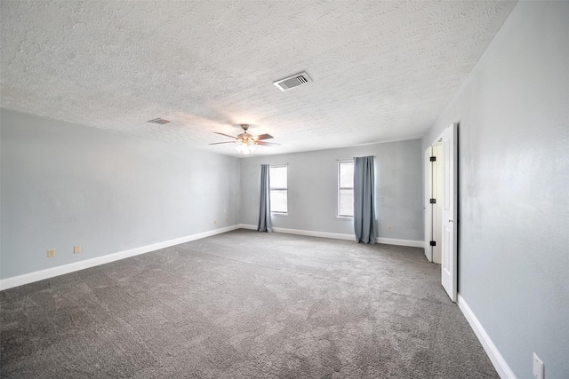 carpeted spare room with visible vents, a textured ceiling, baseboards, and ceiling fan