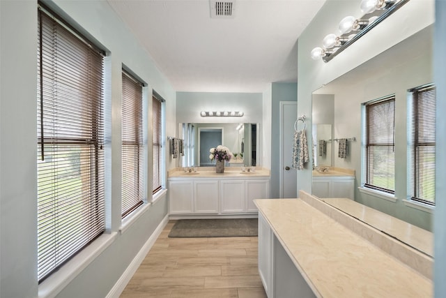 full bathroom featuring vanity, wood finished floors, visible vents, and baseboards