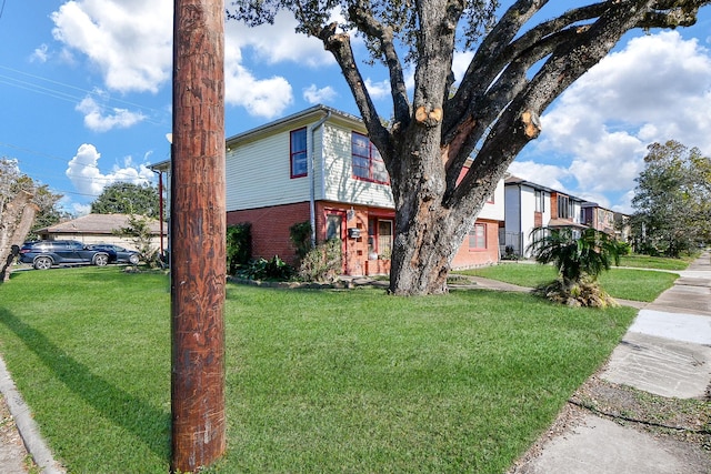 view of side of home featuring brick siding and a yard