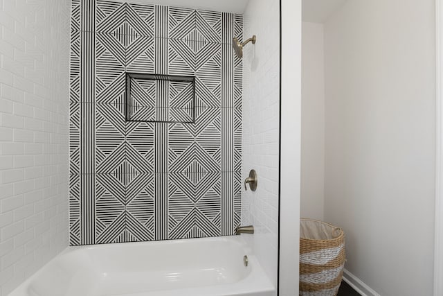 bathroom featuring baseboards and bathtub / shower combination