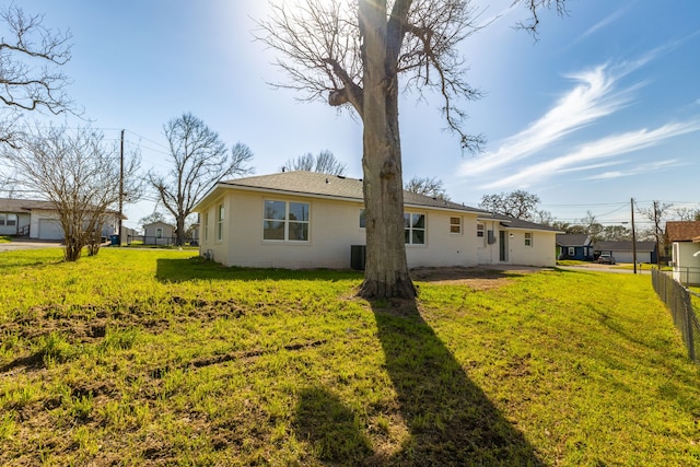 back of property with a yard and fence