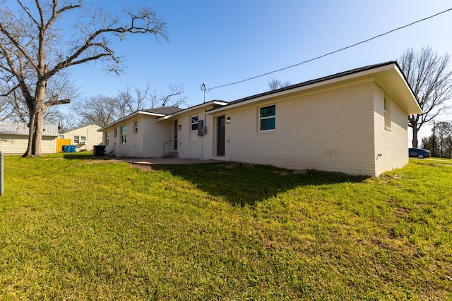 back of property featuring a patio, brick siding, and a lawn