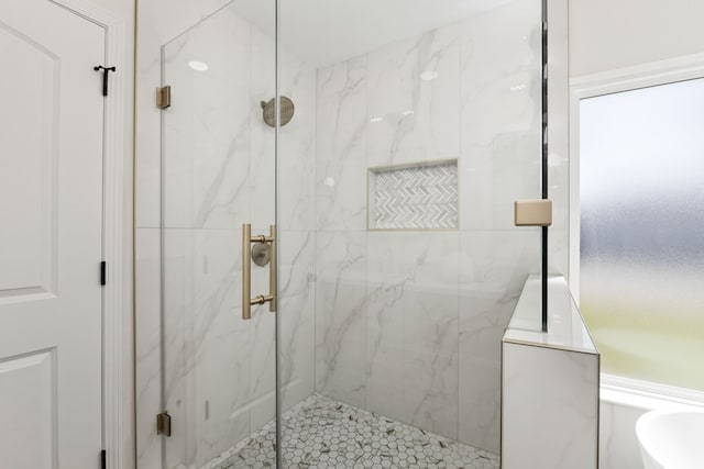 bathroom featuring a marble finish shower