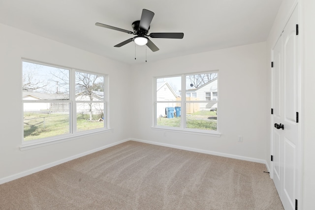 unfurnished bedroom with a closet, multiple windows, light colored carpet, and baseboards