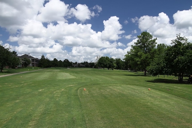 view of home's community with a lawn and view of golf course