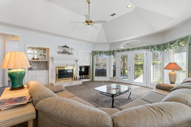 living room featuring visible vents, high vaulted ceiling, a ceiling fan, a high end fireplace, and french doors