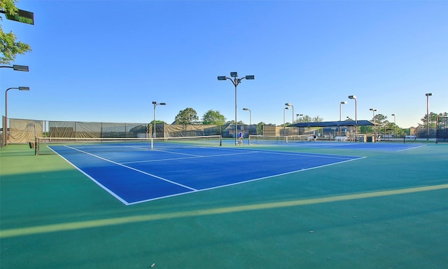 view of tennis court featuring fence