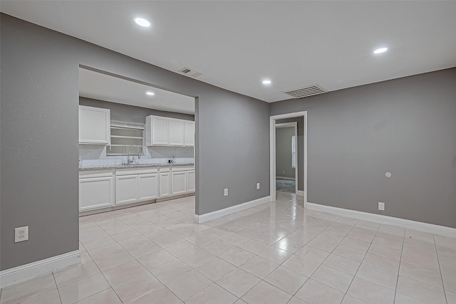 spare room featuring visible vents, recessed lighting, baseboards, and a sink