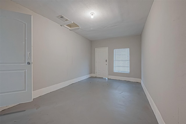 unfurnished room featuring visible vents, a textured ceiling, finished concrete flooring, and baseboards