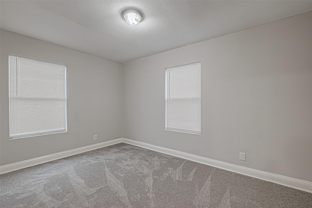 unfurnished room featuring a textured ceiling, baseboards, and carpet floors