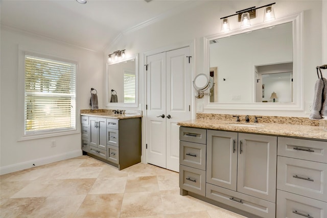 bathroom featuring a sink, vaulted ceiling, two vanities, and ornamental molding