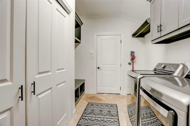 washroom featuring light tile patterned floors, cabinet space, crown molding, and washing machine and clothes dryer