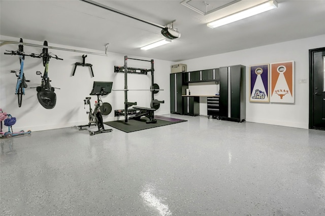 workout area with attic access, baseboards, and a garage