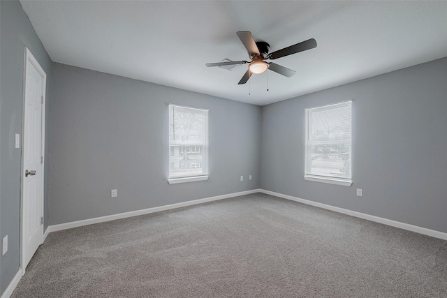 empty room featuring carpet flooring, baseboards, a wealth of natural light, and ceiling fan