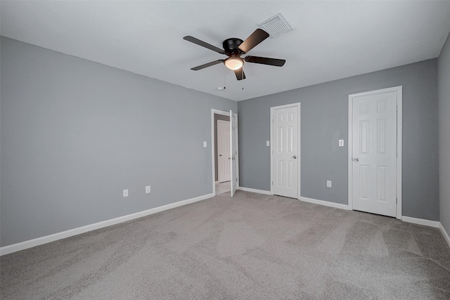 unfurnished bedroom with baseboards, visible vents, carpet floors, and ceiling fan