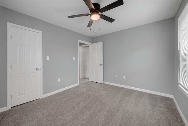 unfurnished bedroom with multiple windows, baseboards, and carpet floors