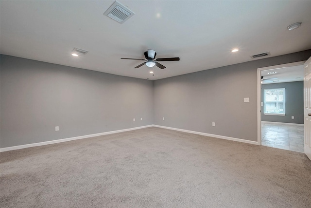 unfurnished room with visible vents, carpet, and a ceiling fan