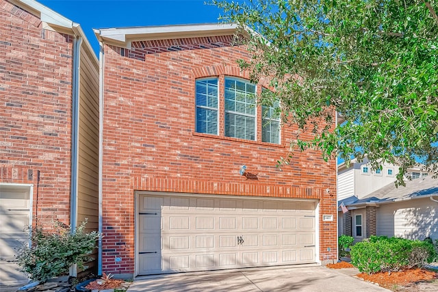 view of front facade featuring an attached garage, brick siding, and driveway