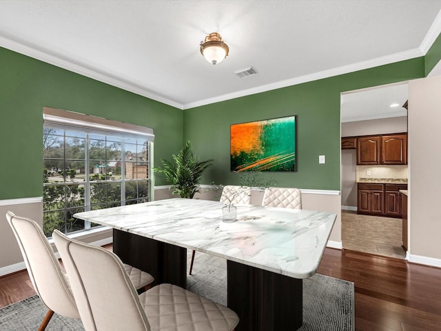 dining space with visible vents, baseboards, dark wood finished floors, and crown molding