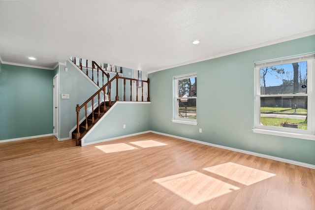 interior space with crown molding, stairway, wood finished floors, and baseboards