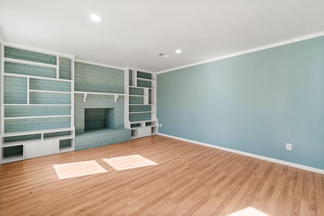 unfurnished living room with crown molding, wood finished floors, visible vents, and baseboards