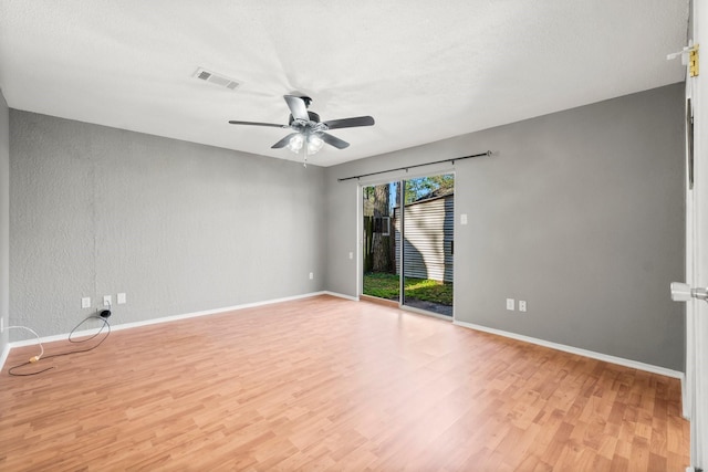 spare room with light wood finished floors, visible vents, ceiling fan, and baseboards