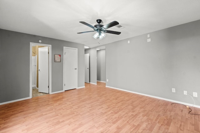 empty room featuring visible vents, light wood-style flooring, a ceiling fan, and baseboards