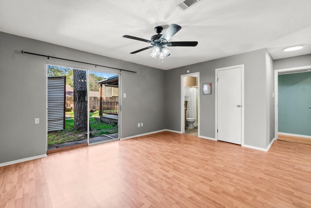 unfurnished room with light wood-style flooring, visible vents, and a textured ceiling