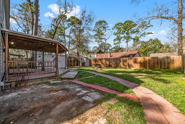 view of yard featuring a deck, an outdoor structure, a storage shed, and a fenced backyard